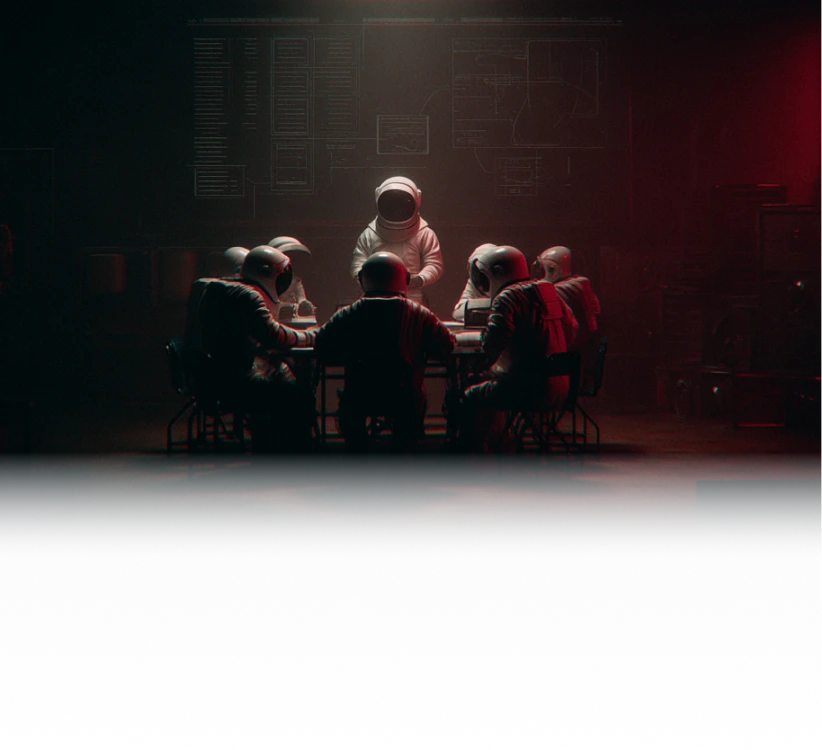 A group of astronauts seated around a table in a dark room, with one astronaut standing and illuminated in the center.