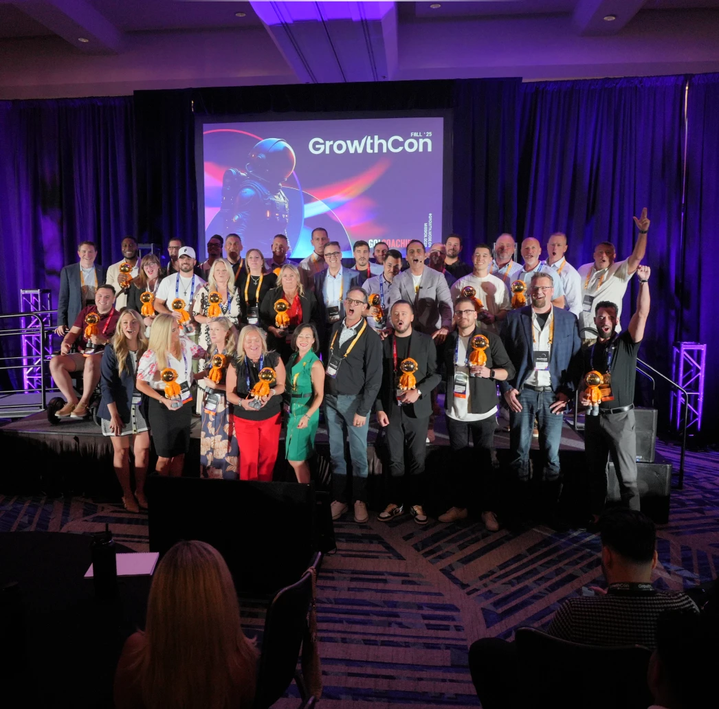 Group of people holding orange astronaut-shaped awards on stage in front of a screen displaying 'GrowthCon'.