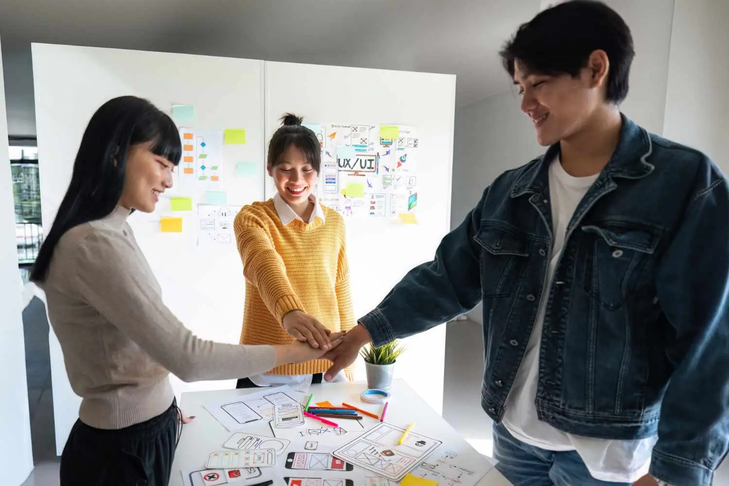 Three friends singing and recording a video together on a smartphone mounted on a tripod.