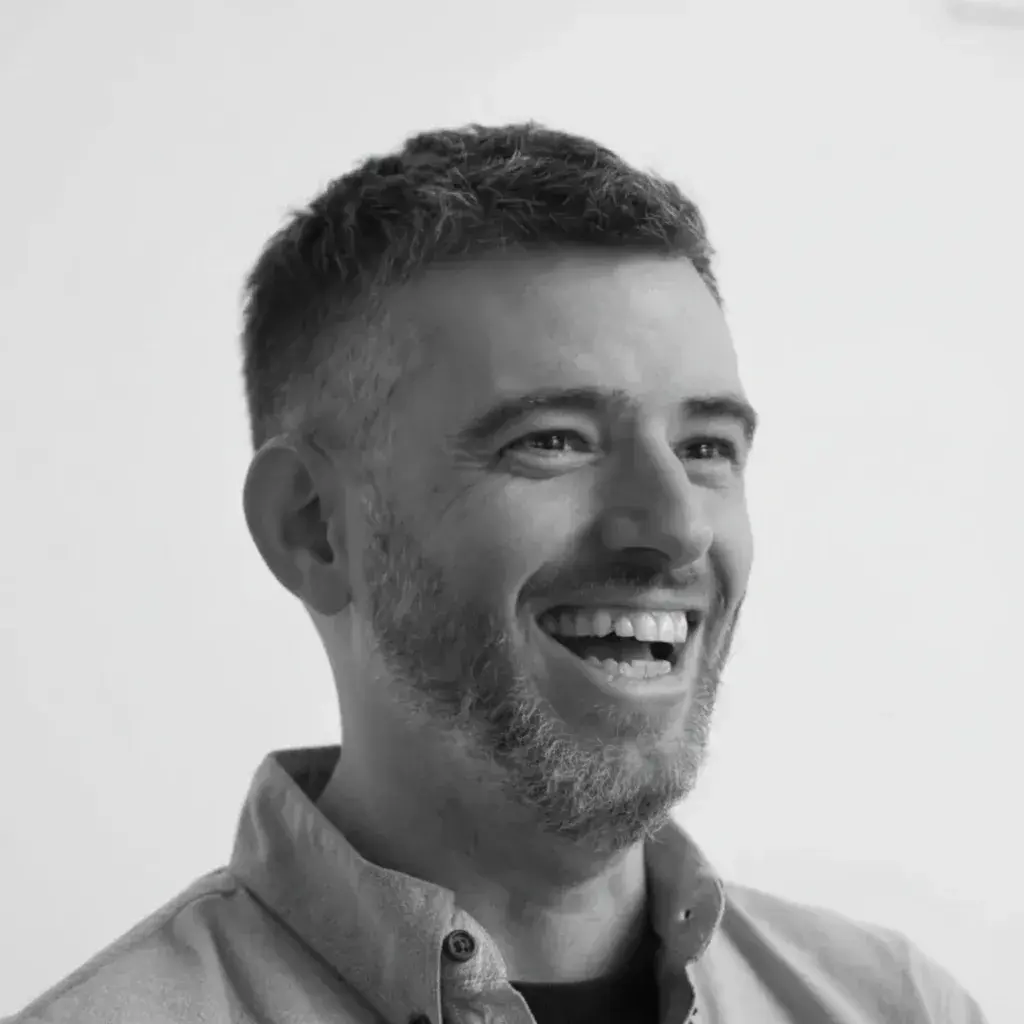 A black and white photo of a man smiling