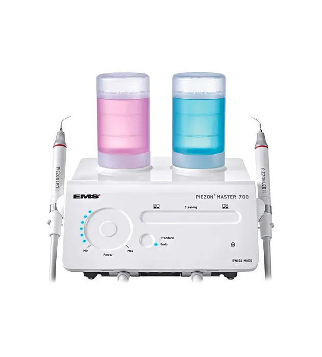 EMS Piezon Master 700 zubní přístroj s růžovou a modrou nádobou na kapaliny a dvěma piezoelektrickými nástavci.