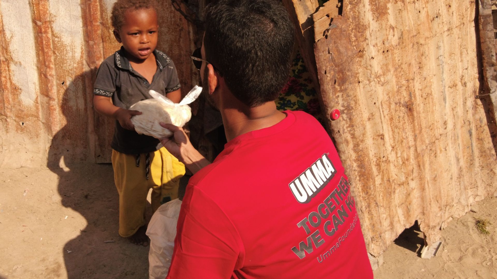 UMMA volunteer giving aid to child