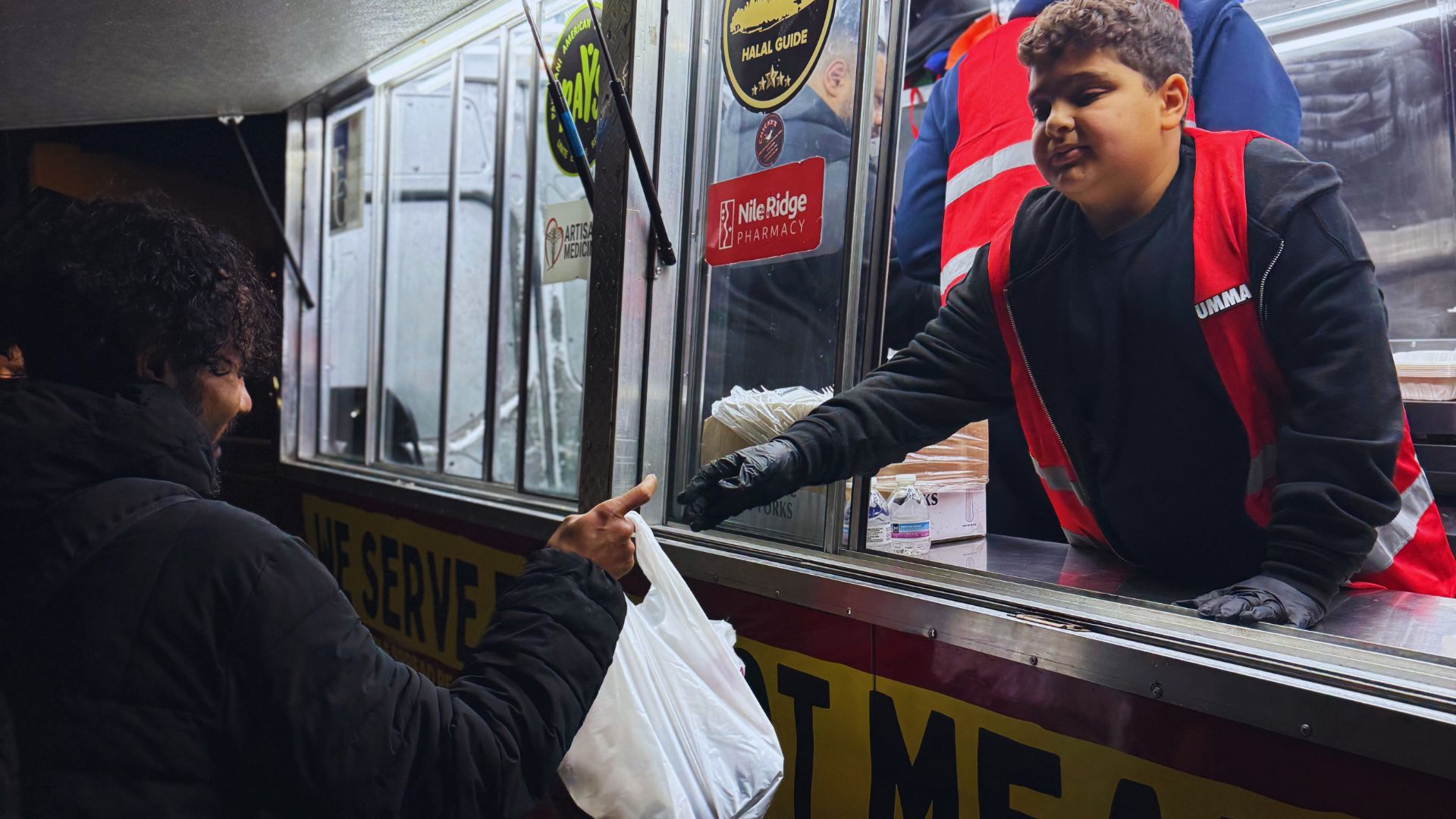 Umma volunteer handing out halal food 