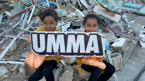 girls in Gaza holding UMMA sign .