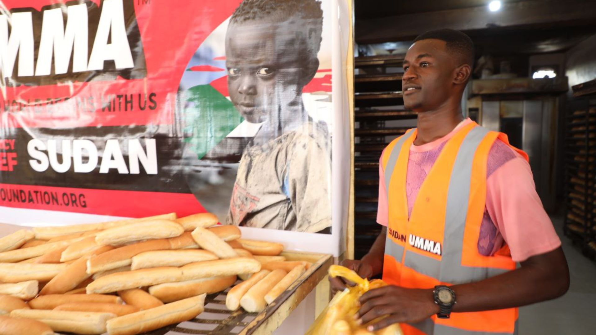 Sudan relief volunteer with Umma Foundation preparing fresh bread for vulnerable displaced families in crisis.