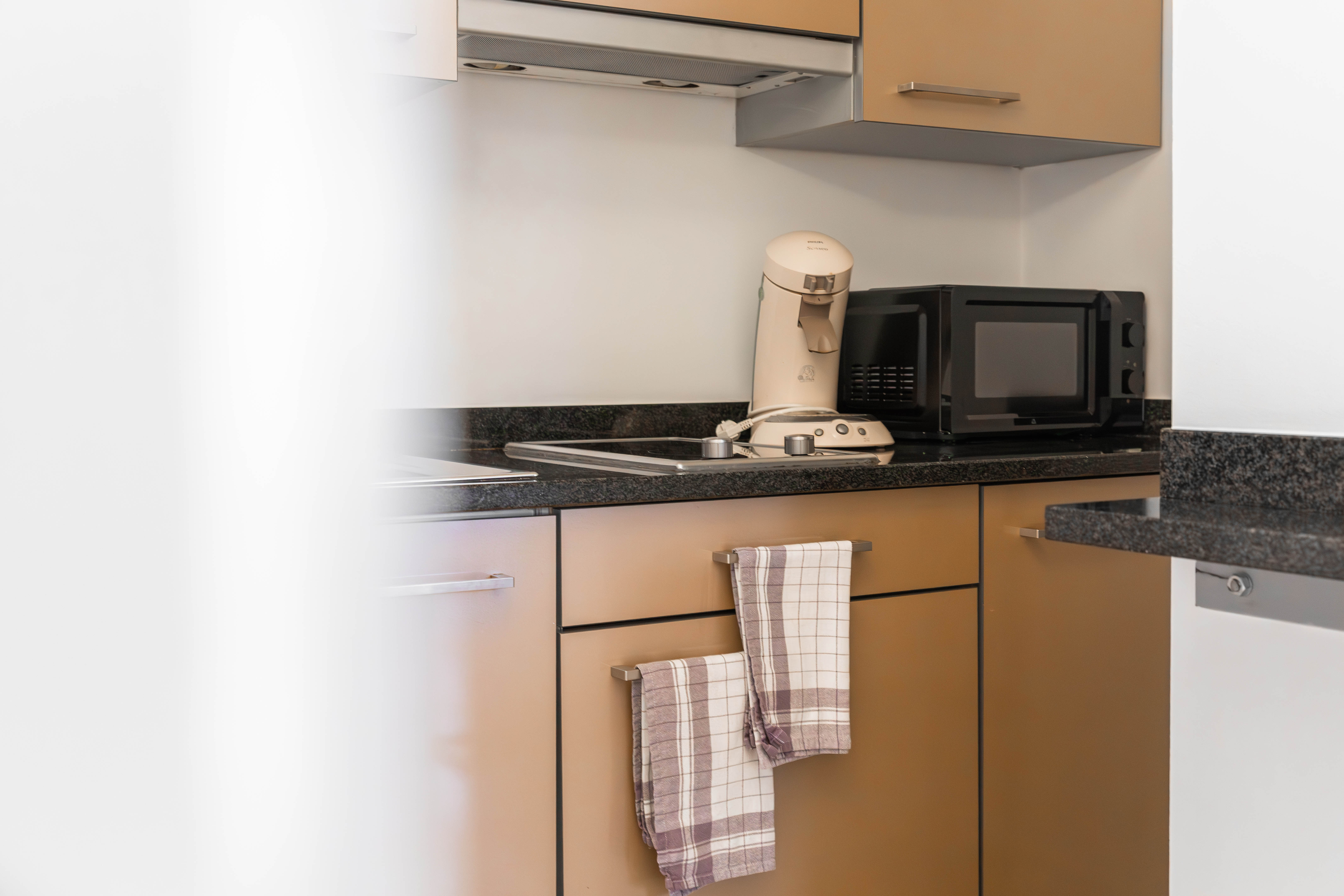 Mensen lopen en winkelen voor een modern winkelcentrum met een ingang gemarkeerd 'shopping' op een zonnige dag.