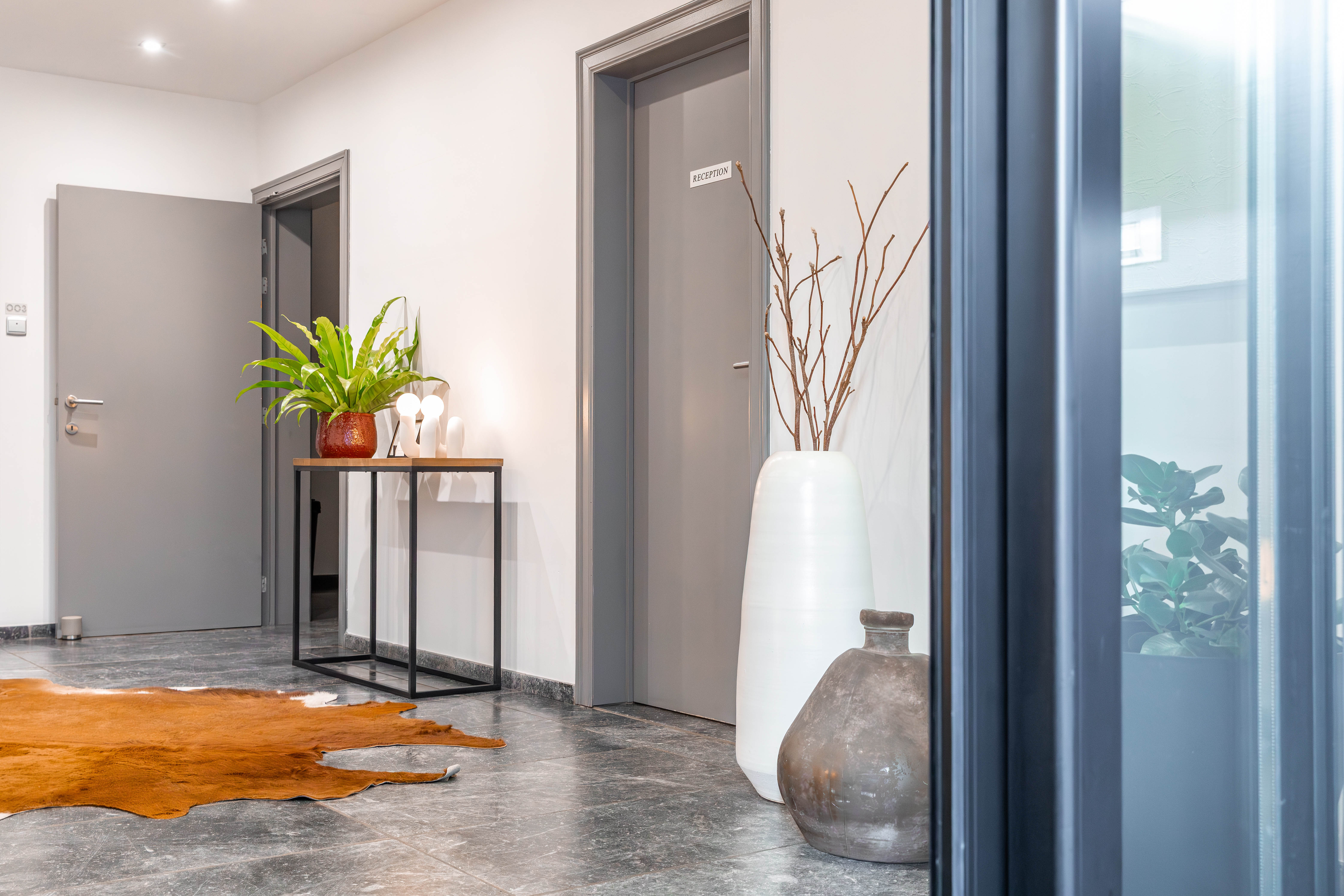 Twee eenpersoonsbedden met witte lakens en kussens in een moderne hotelkamer met houten hoofdeinden en een nachtkastje.