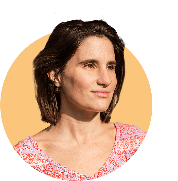 Porträt von Isabel, lächelnd vor ruhigem Hintergrund.