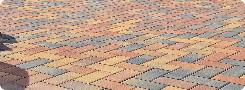 Bunte gepflasterte Bodenfläche mit rechteckigen Steinen in verschiedenen Farben.