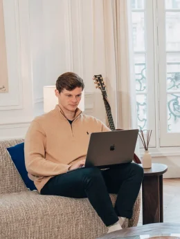 Une femme debout devant un écran de projection, donnant une présentation avec une télécommande en main.