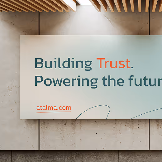 Wall-mounted banner with the text 'Building Trust. Powering the future' and the website address atalma.com.
