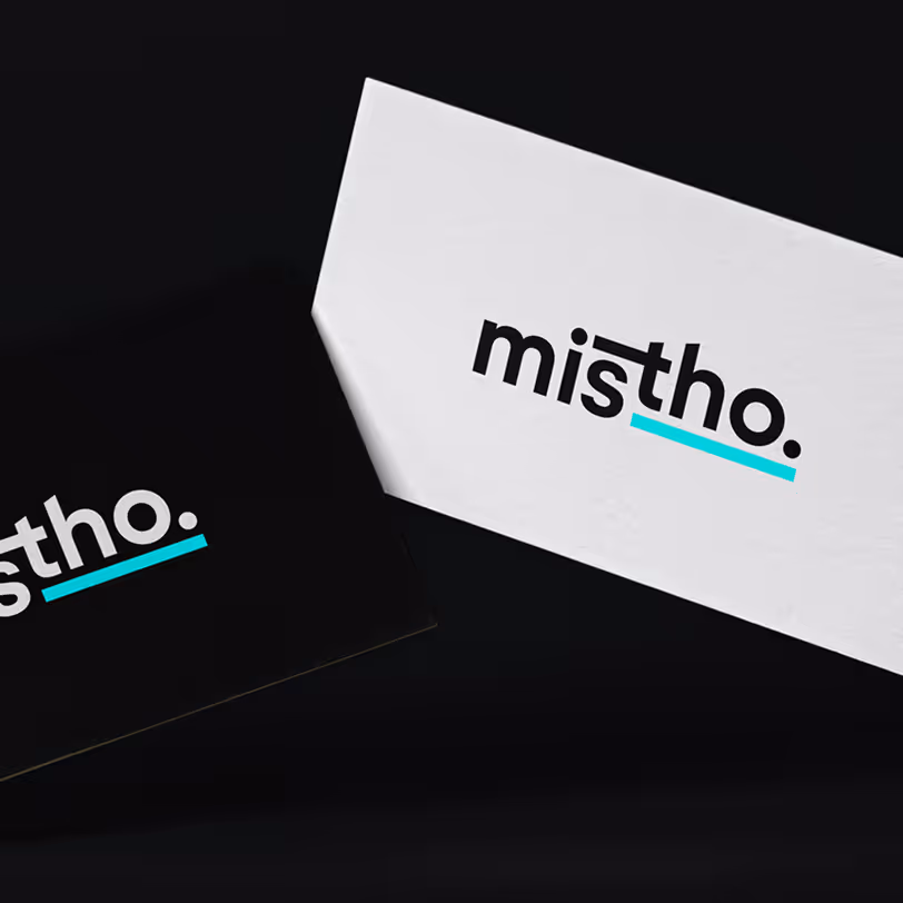Two business cards, one black and one white, both displaying the brand name 'mistho.' with a turquoise underline under 'tho.'