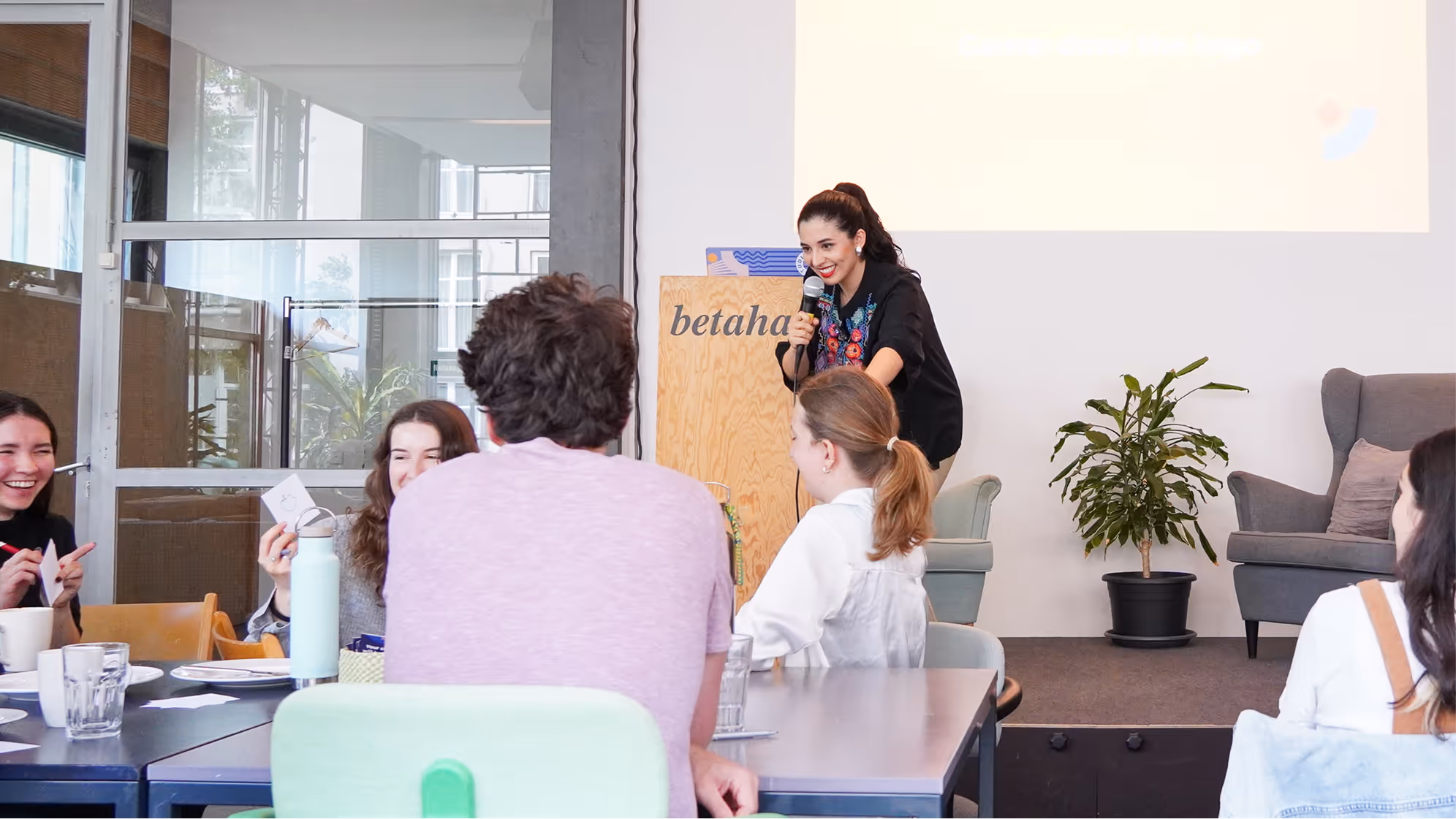 Video call screen showing four diverse professionals smiling and engaging, each in their own home or office backgrounds.