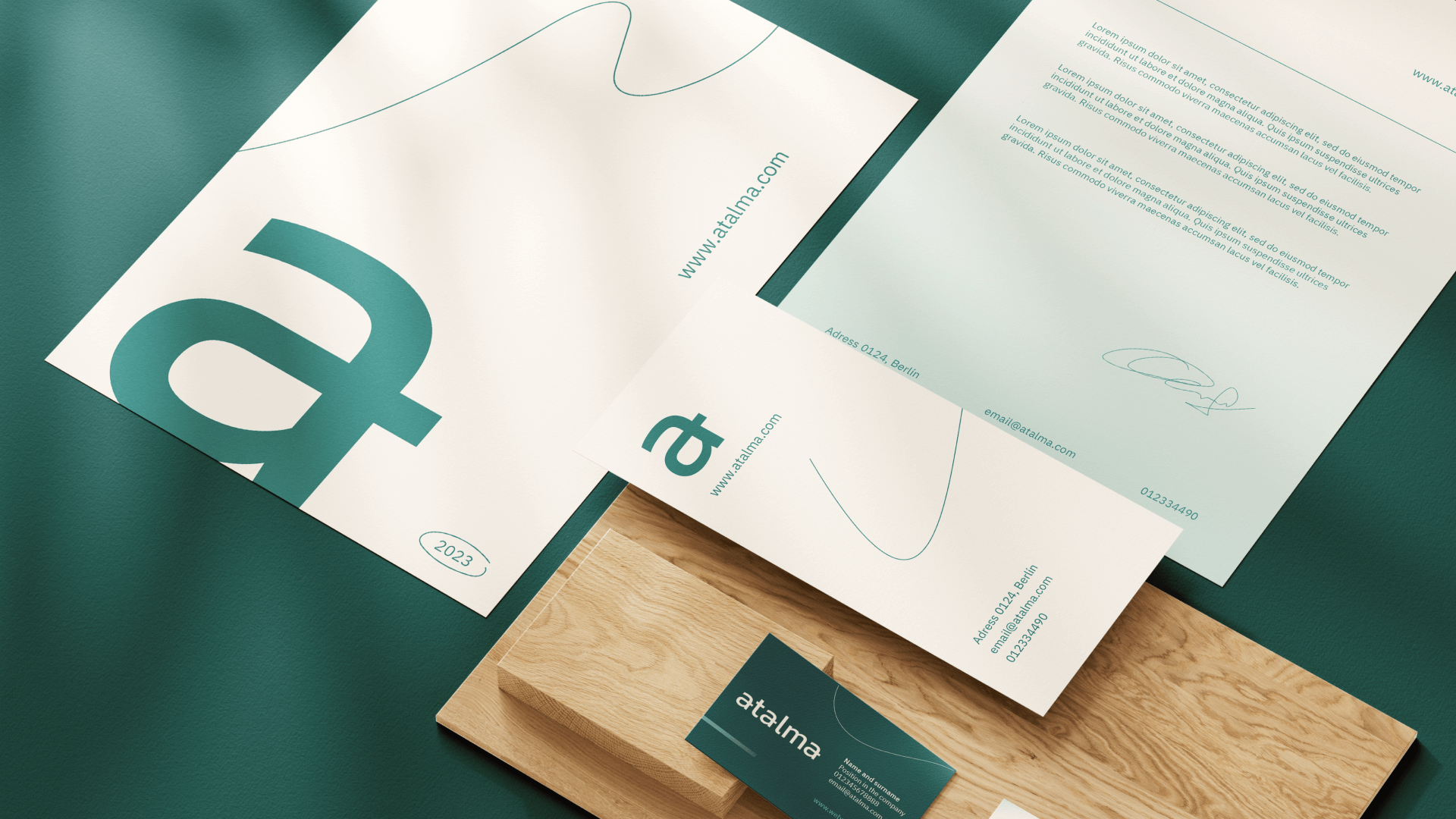 Set of branded stationery items including letterhead, envelope, and business card with teal and white design featuring the text 'atalma' and website www.atalma.com.