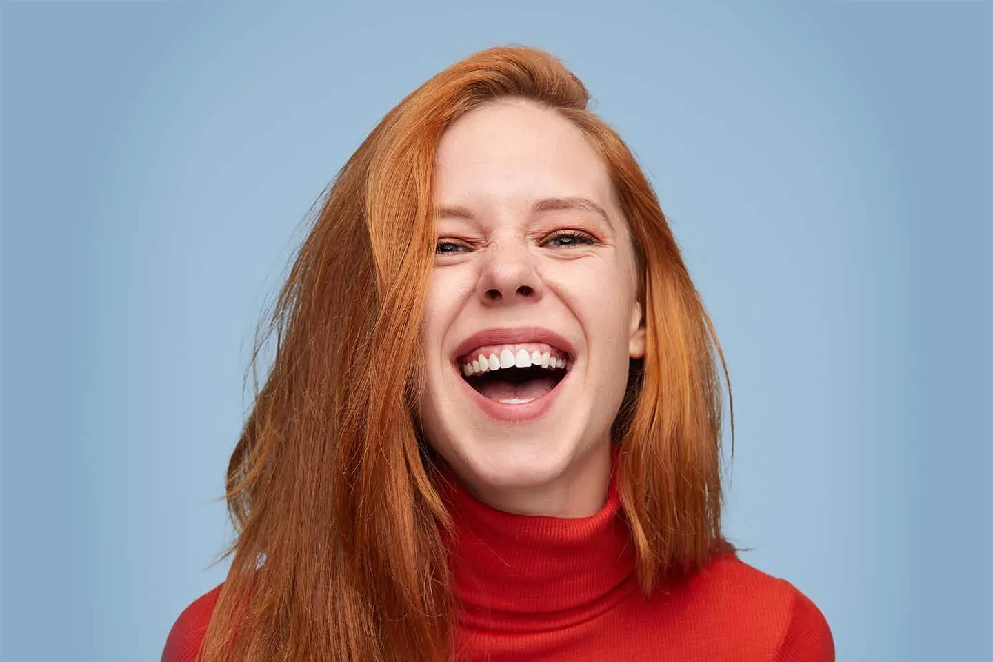 A woman with red hair and a smile on her face.