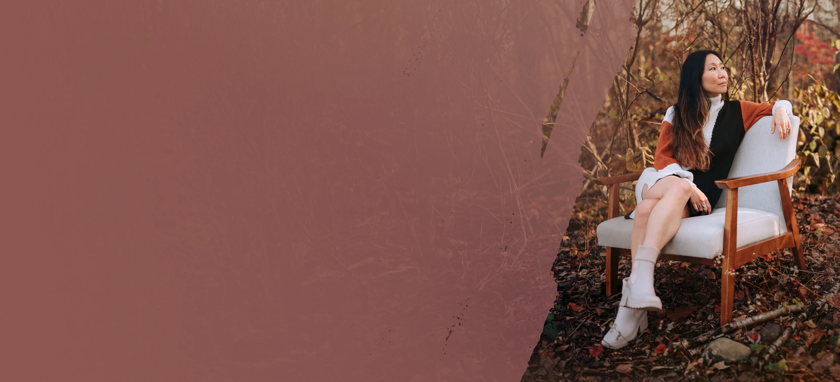 Founder Rachel Forbes wearing a color-block sweater dress sitting on a modern wooden armchair outdoors amid fall foliage.