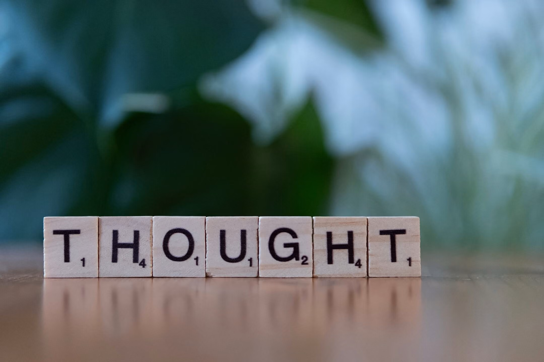 Scrabble tiles spelling thought for a CBT article about cognitive behavioral therapy and shifting perspectives.