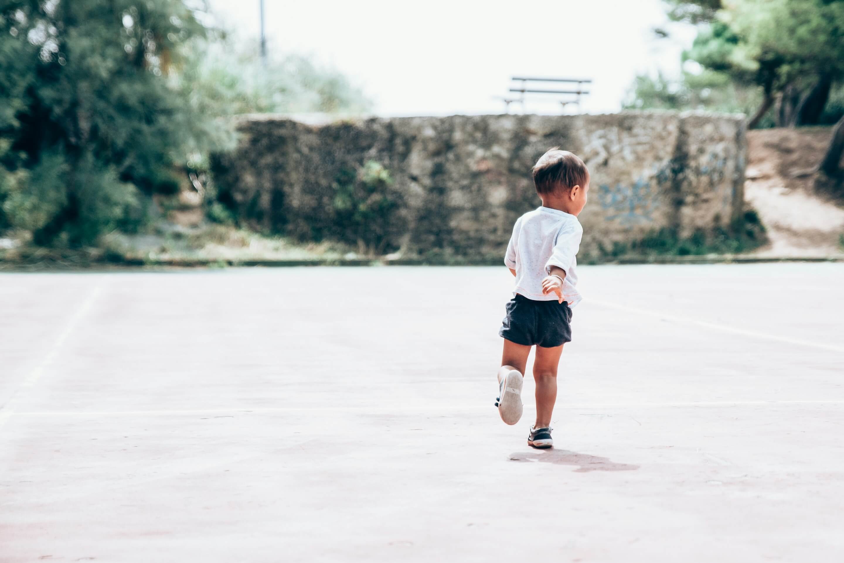 Young child running alone outdoors, representing adoption trauma, separation, and the path to healing through therapy.