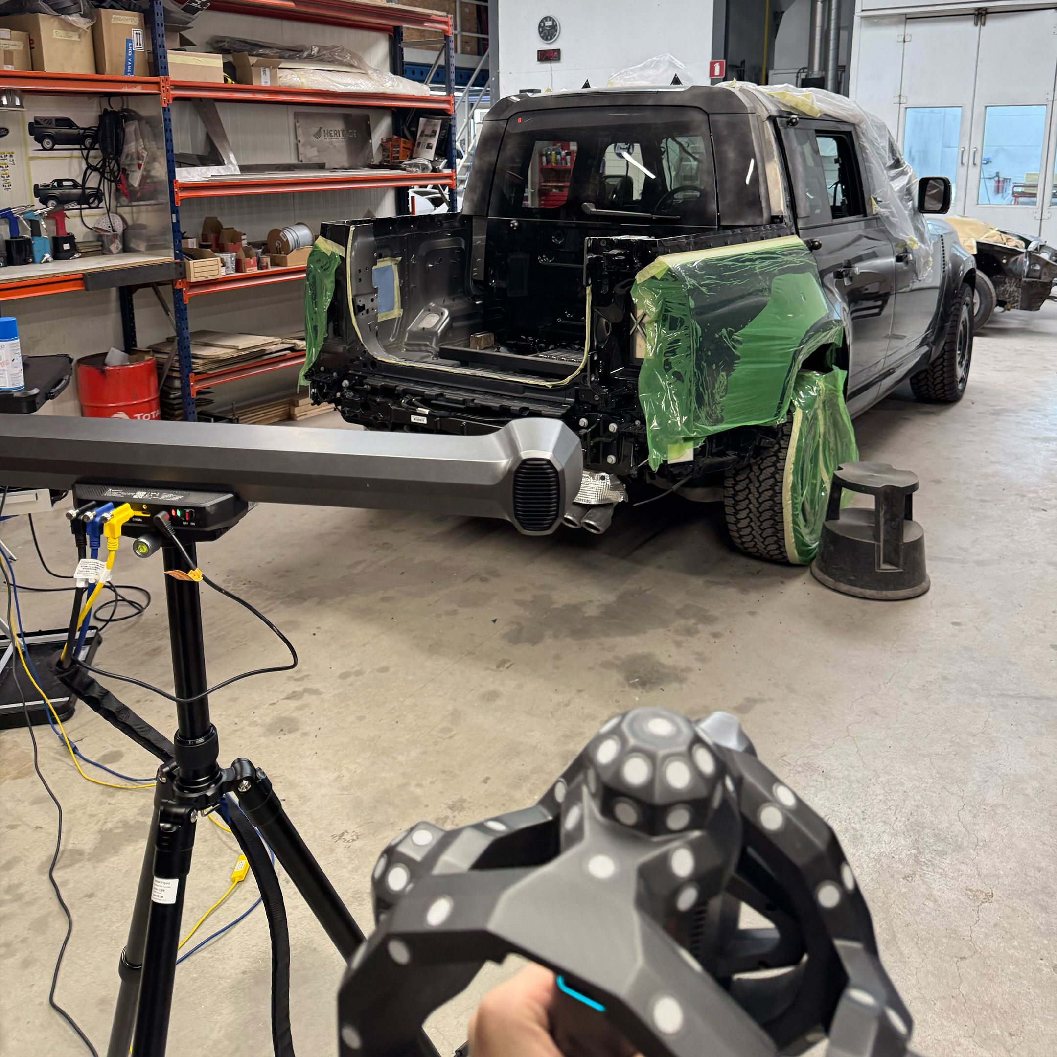 A Land Rover Defender on location, with the optical tracker set up on its tripod