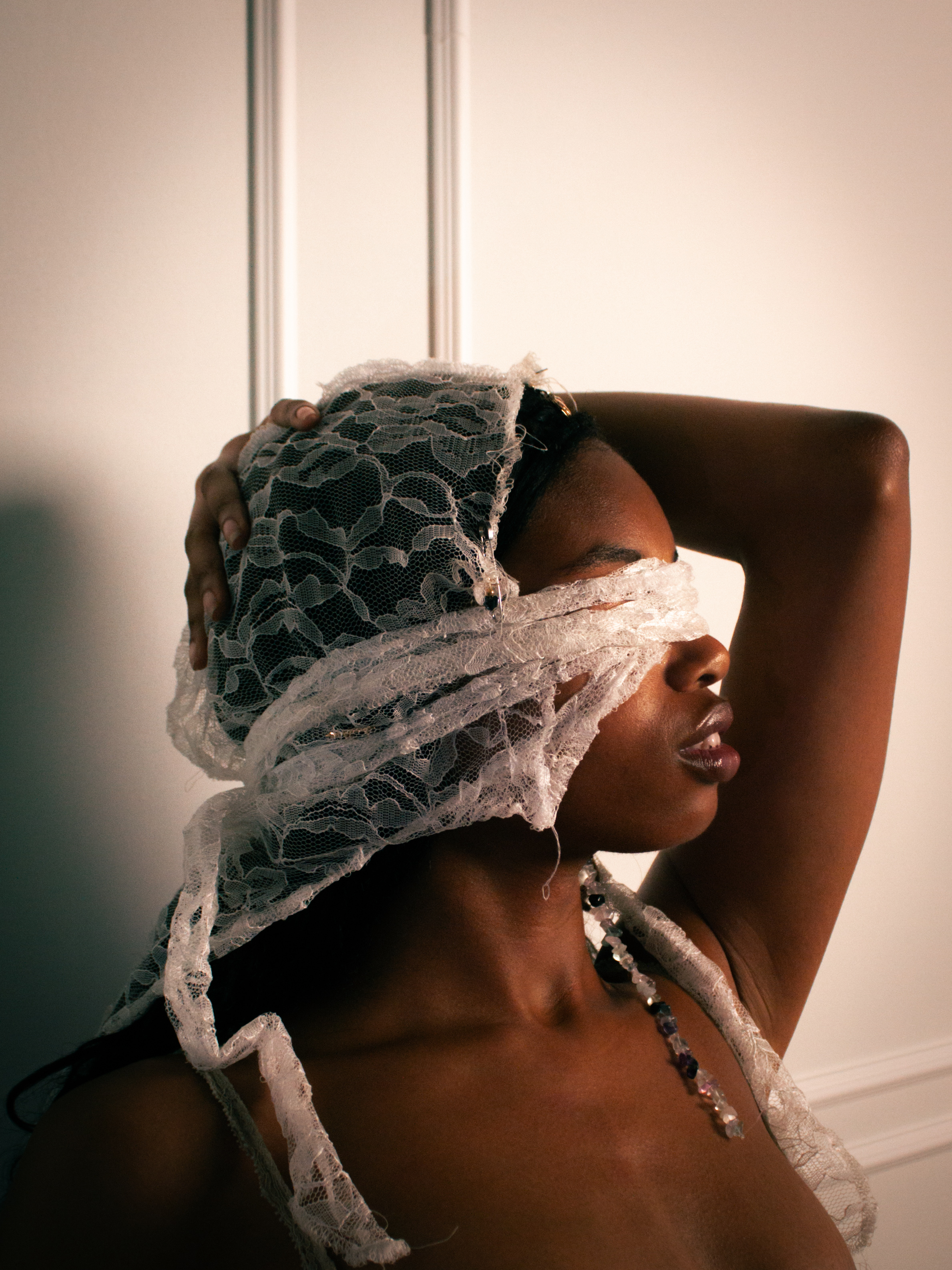 Person posing in a photography studio with backdrops, lighting equipment, and reflective floor panel.