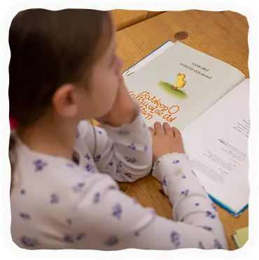 Deklica ob prebiranju knjige.