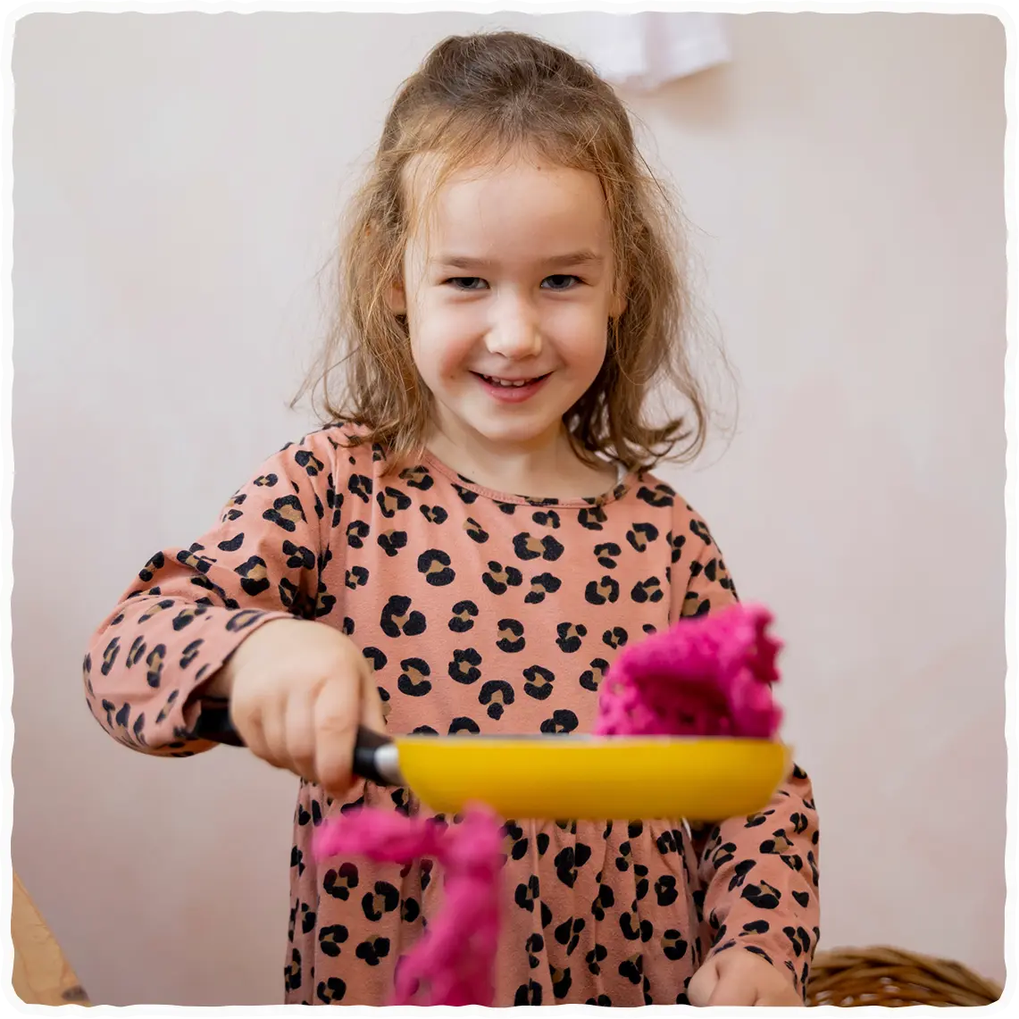 Deklica, ki peče navidezne palačinke.