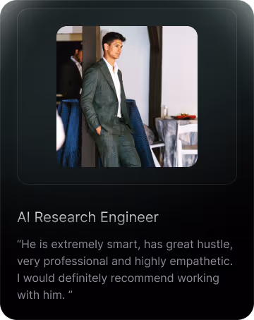 A man in a gray suit standing with hands in pockets in a professional indoor setting.