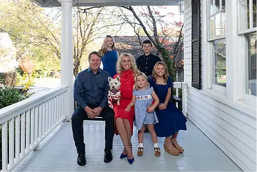 Ashely-Nicole Russell sitting with her family on a porch swing
