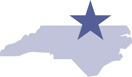A figure of North Carolina overlaid with a star