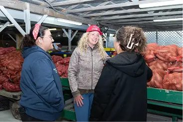 Ashely-Nicole Russell standing and talking to a small-business owner