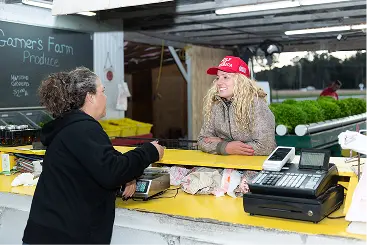 Ashley-Nicole Russell leaning on a counter talking to a small-business owner