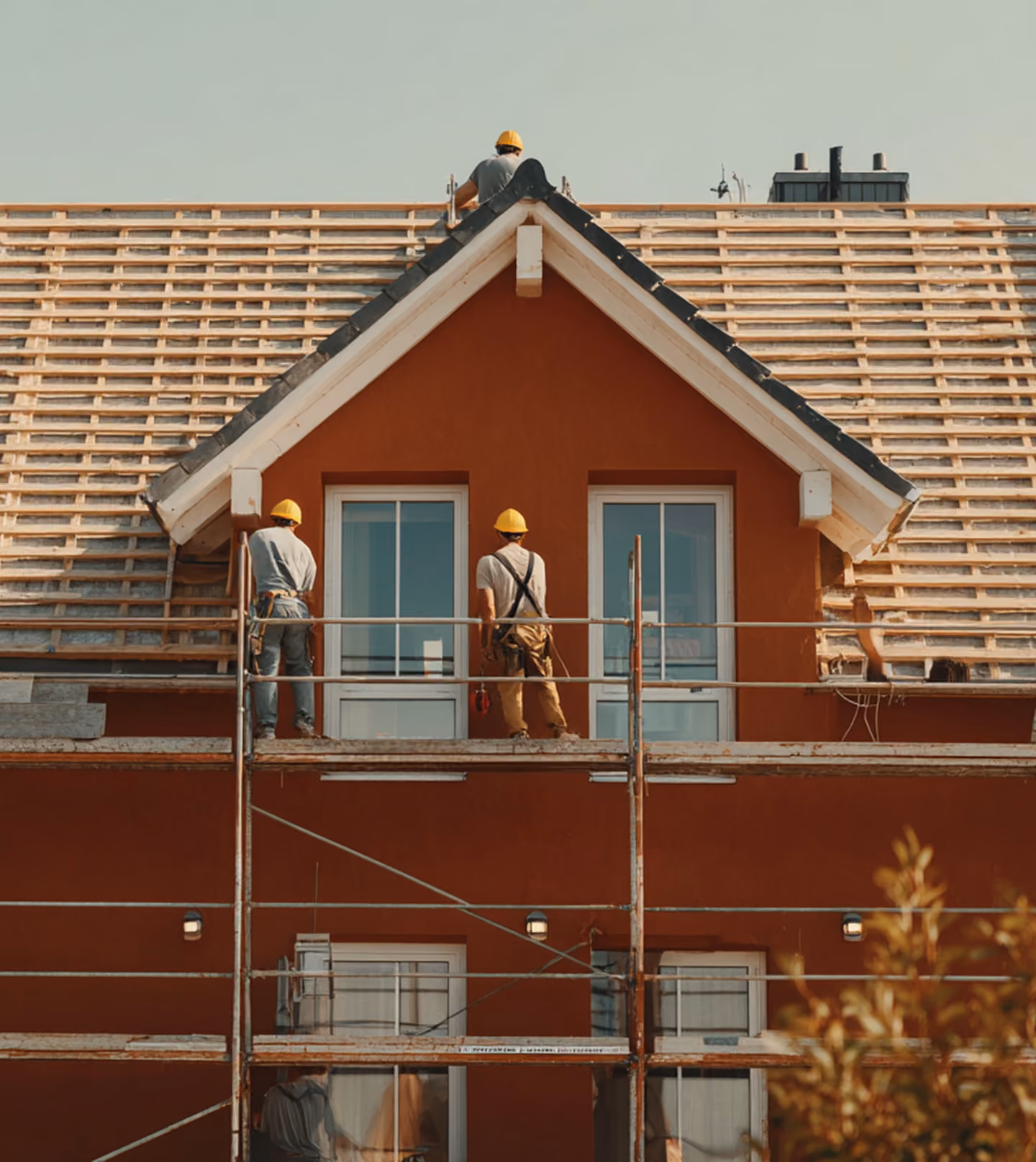 Roofers on scaffolding performing a precise pitched roof measurement for a digital quotation in the Benelux.