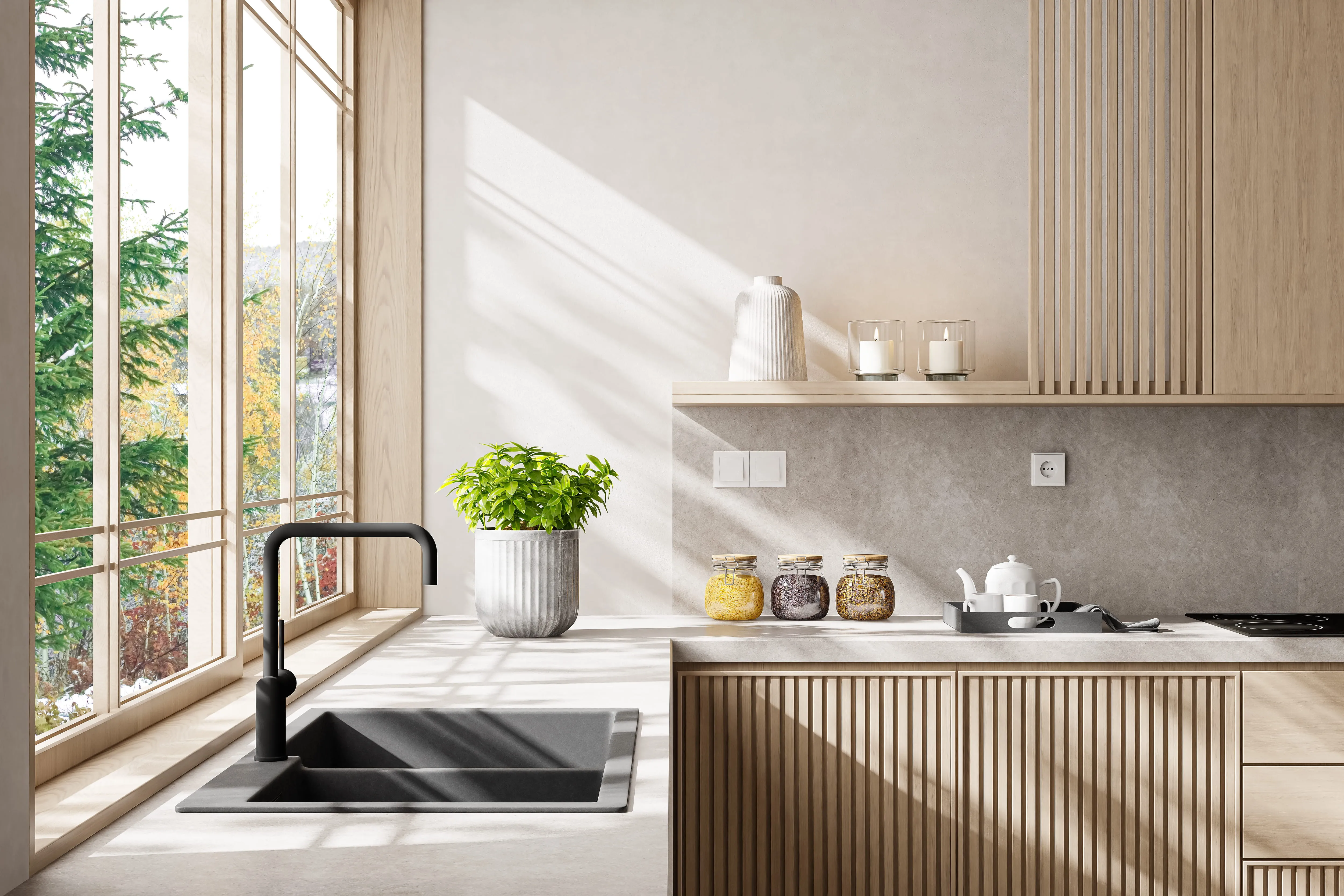 Modern kitchen interior with large windows letting in sunlight, a black sink and faucet, a potted green plant, glass jars with grains on the countertop, and a tray with a white teapot and cups.