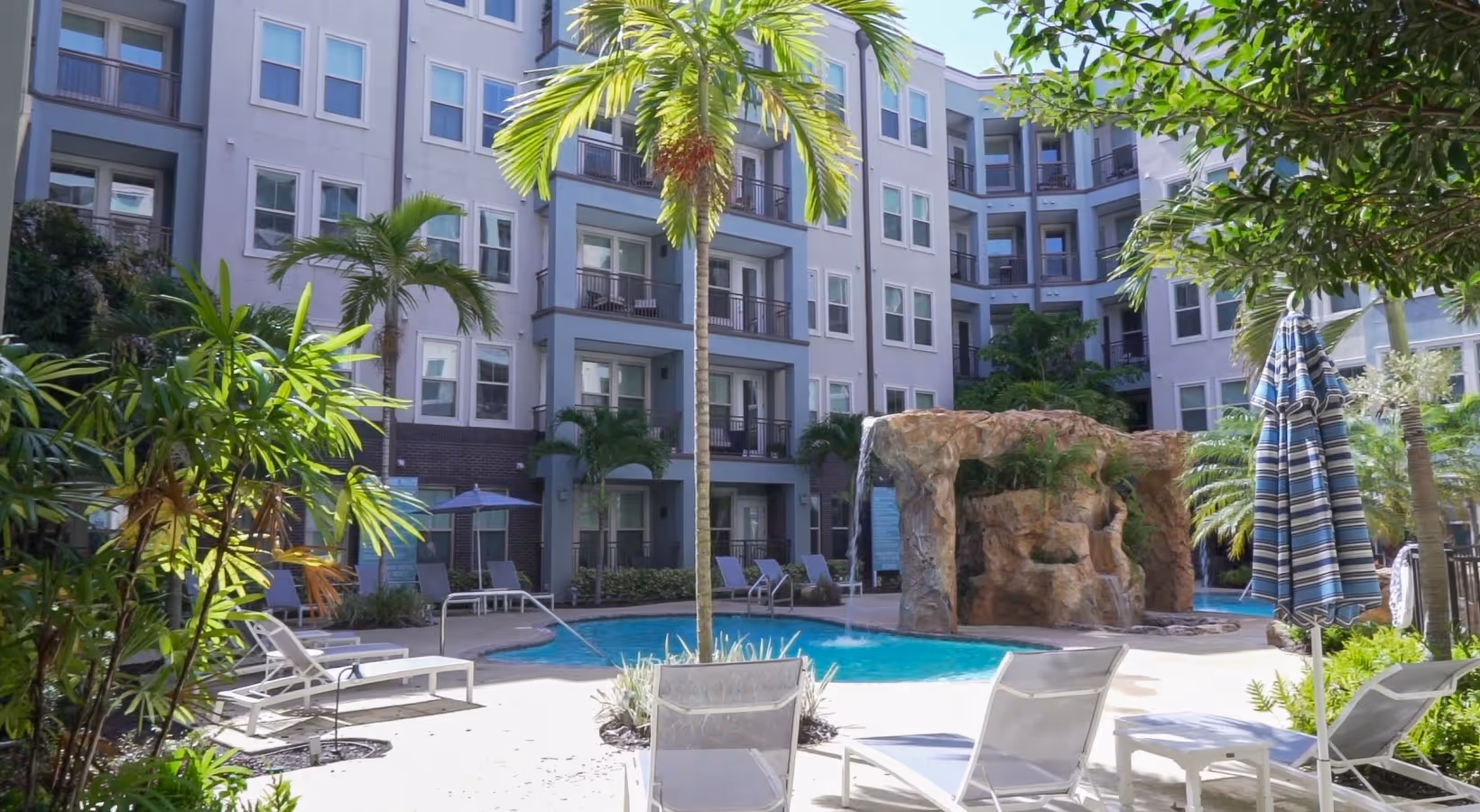 Pool with rock waterfall and palm trees at Novus Westshore