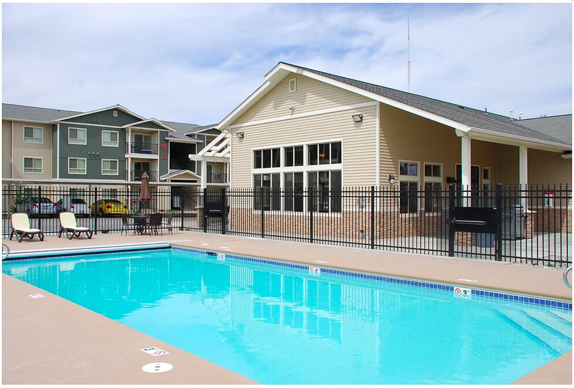 Heated outdoor swimming pool with lounge seating at Copper Hill Apartments in Spokane Valley