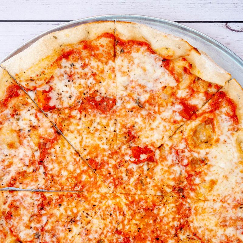 A whole cheese pizza on a metal tray, topped with melted mozzarella and tomato sauce, garnished with herbs. The crust is golden and slightly crisp.
