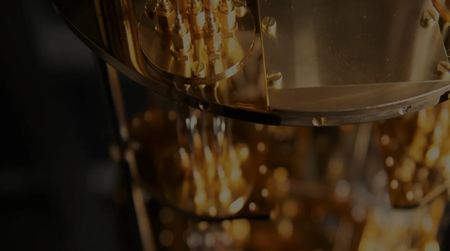 Close-up of complex gold-colored mechanical components with screws and rods.