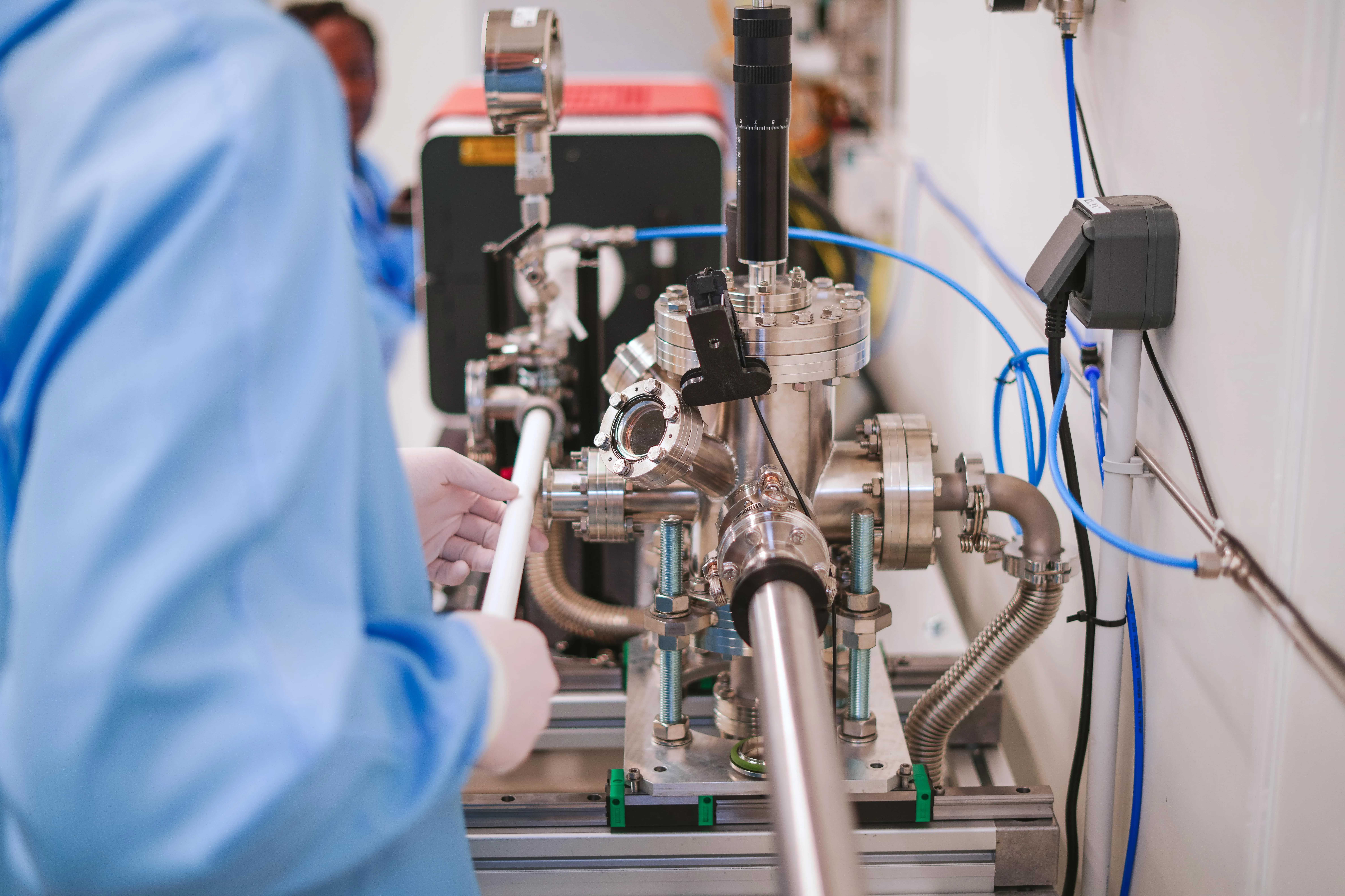 Two scientists wearing blue lab coats working together in a laboratory.