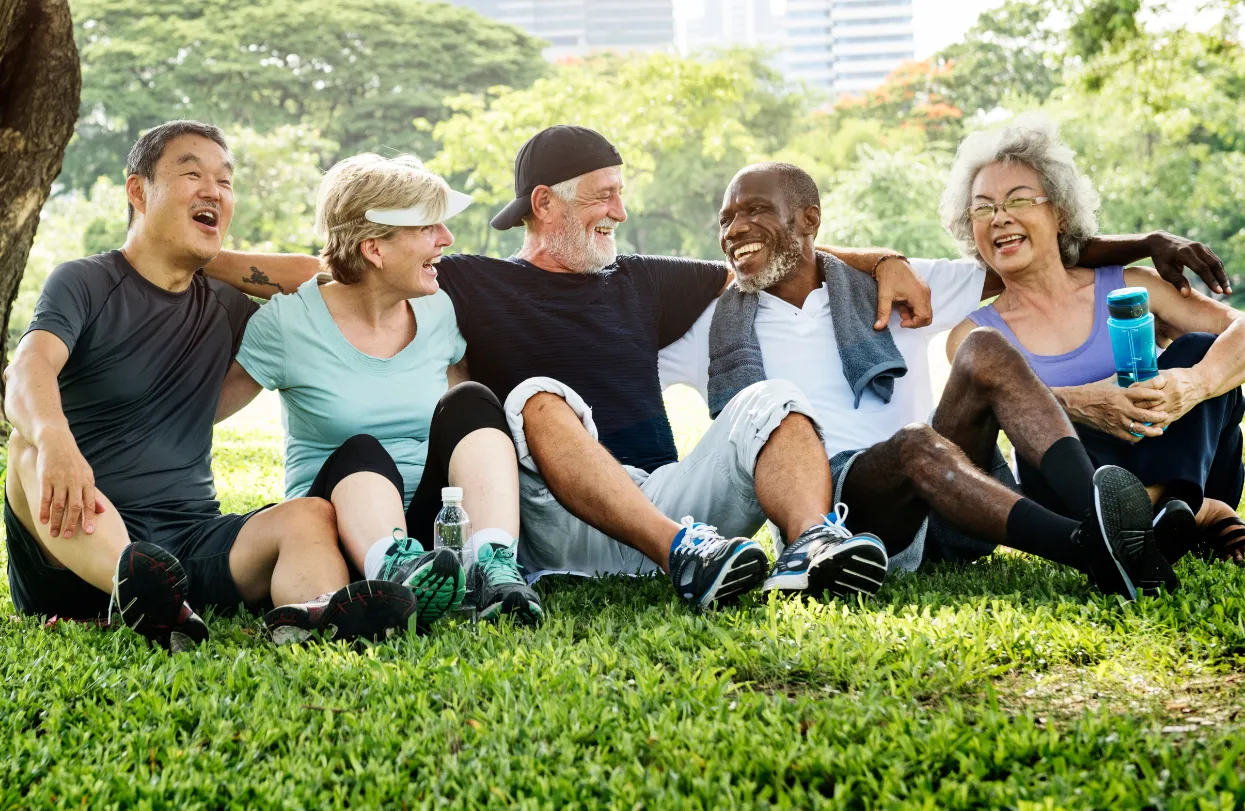 senior friends sitting on grass stock image