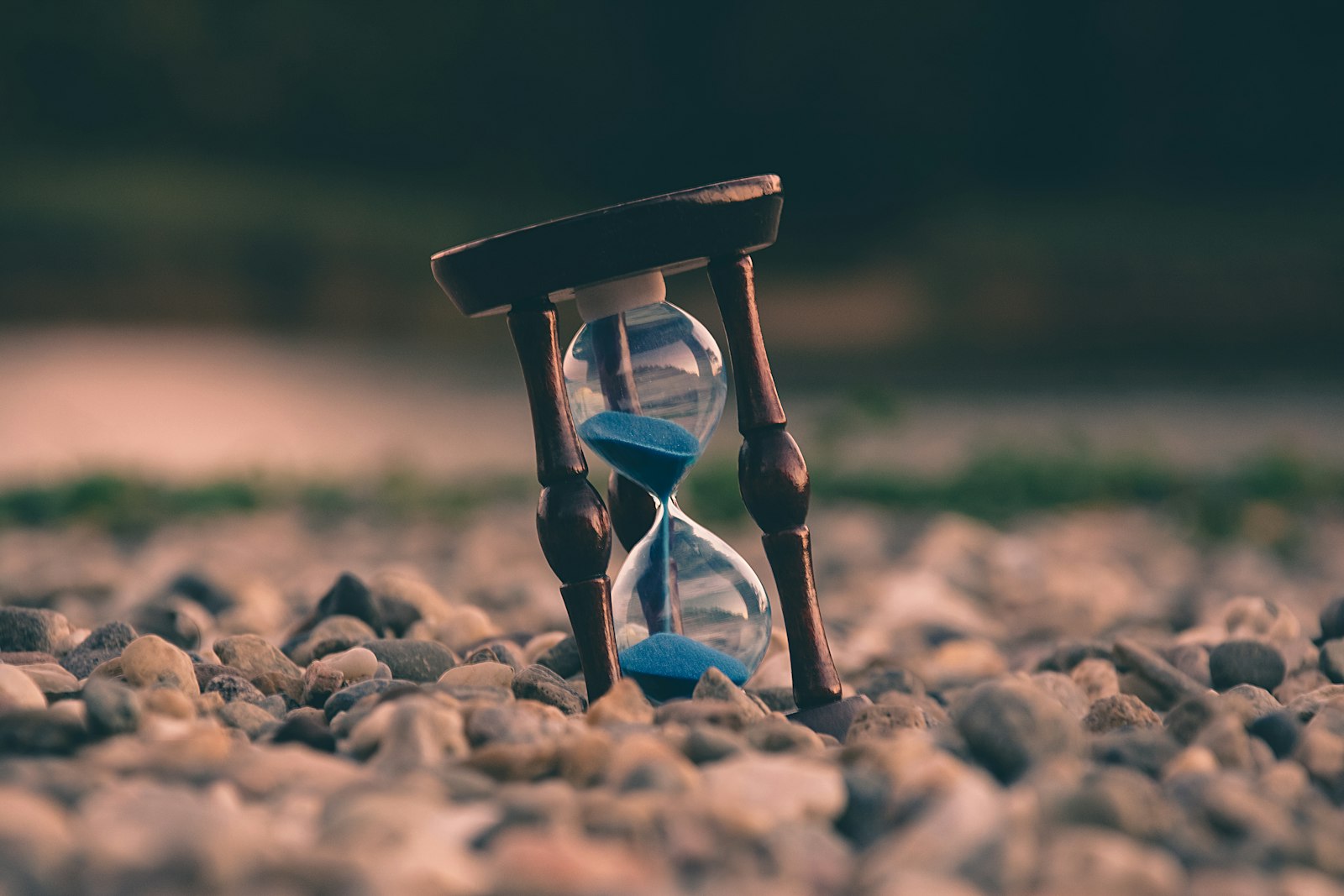 Hourglass with blue sand running out on a gravel path, symbolizing the North Carolina personal injury statute of limitations deadline