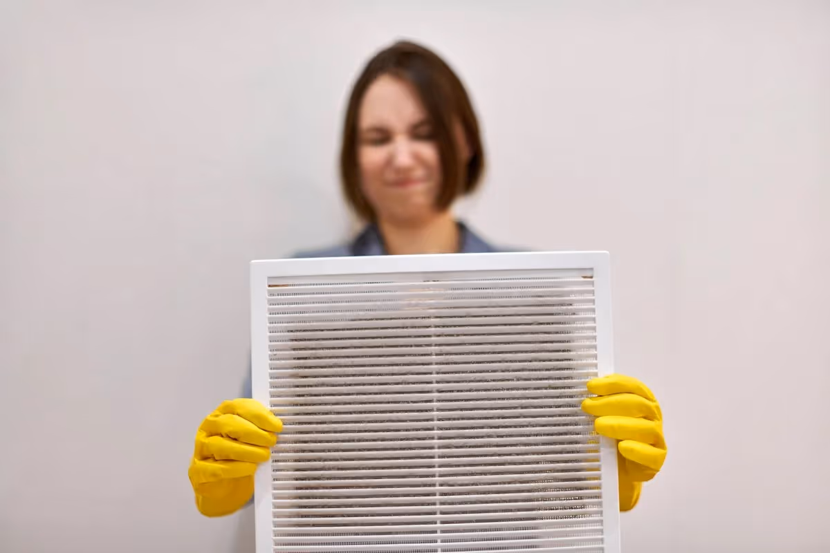 Woman holding a dirty air filter.