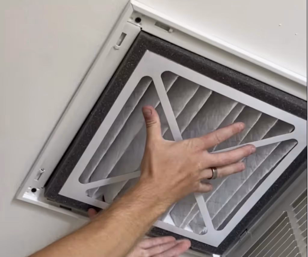 Hands installing a clean air filter.