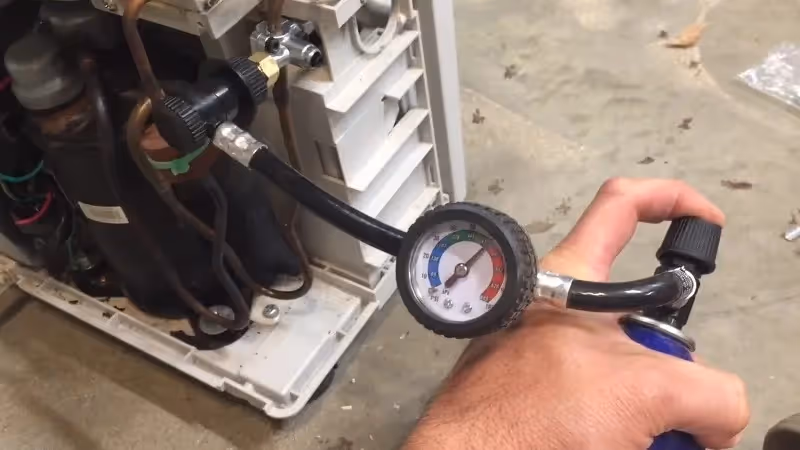 Man refilling refrigerant in portable dehumidifier.