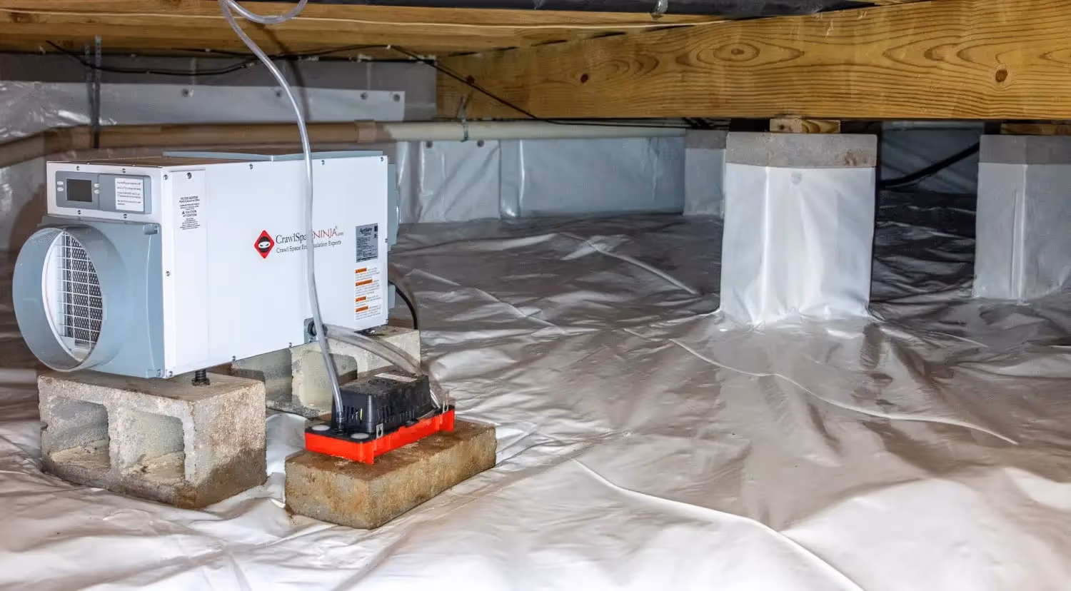 Dehumidifier on blocks in encapsulated crawlspace.