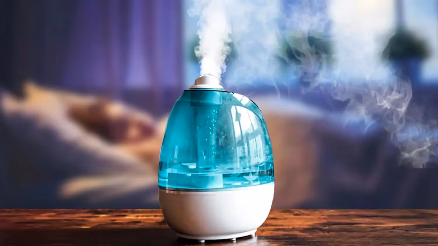 Blue ultrasonic humidifier emitting steady mist.