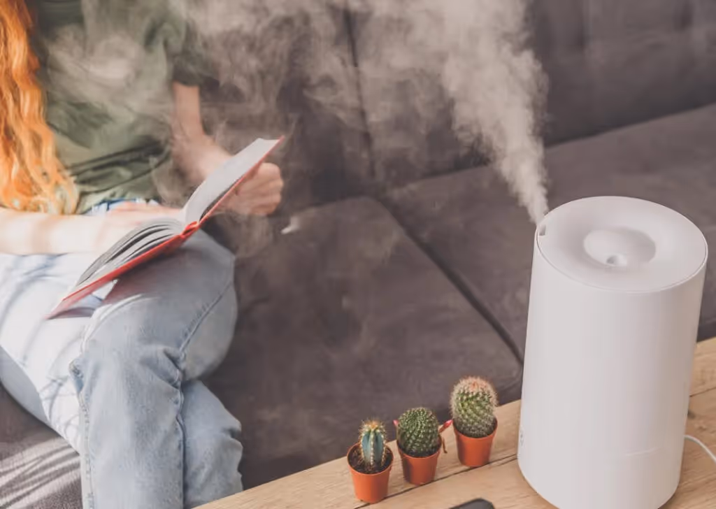 White humidifier emitting mist near reader.