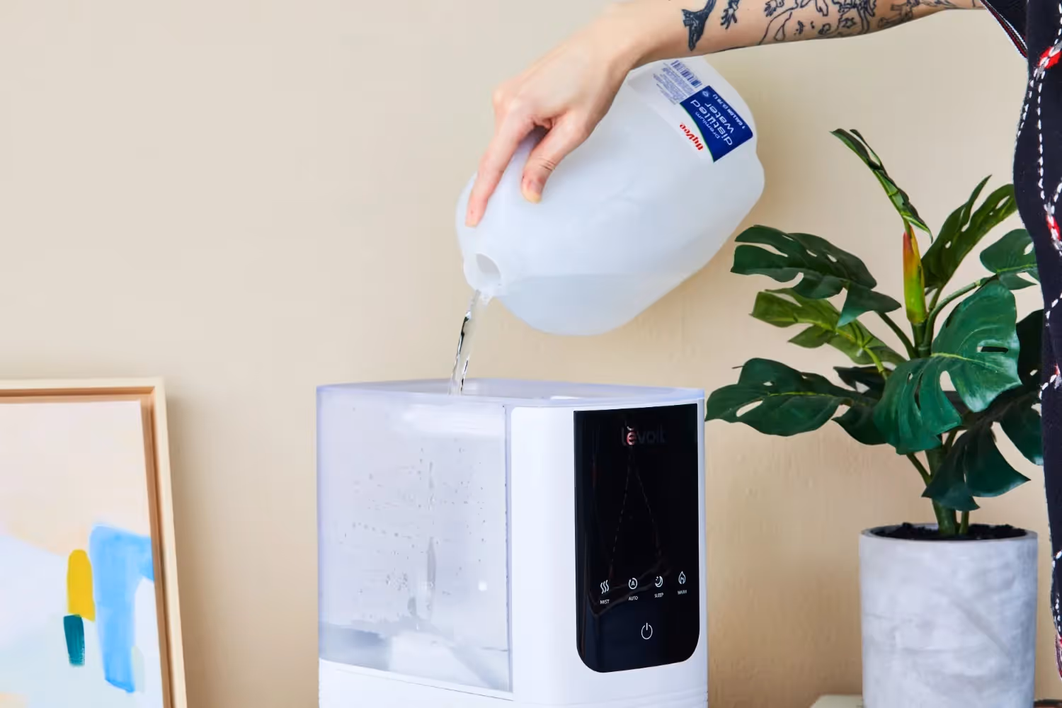 Pouring distilled water into white humidifier.