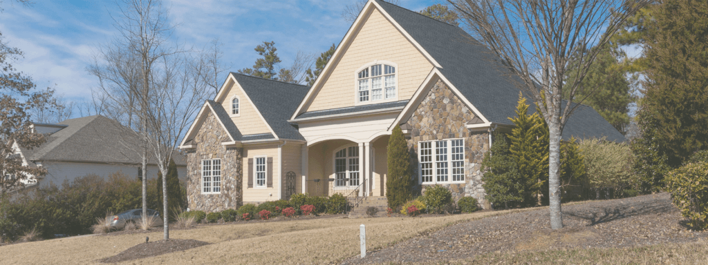 Residential home in Bowling Green, KY with stone and wood exterior, surrounded by landscaped yard and trees, representing quality HVAC services for home comfort.