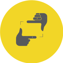 Icon of two gray hands forming a rectangular frame on a yellow circular background.