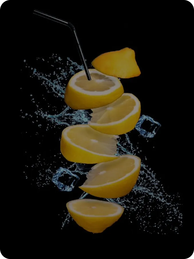 шматочки лимона з бризками води на темному фоні, студійна фуд-фотографія